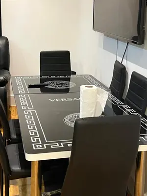 a dining room table with black chairs and a television at Perfect Stay Near Glasgow Town in Glasgow