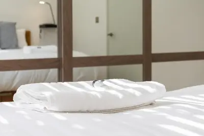 a stack of white towels sitting on top of a bed at Luxury Flat Near Hove Station parking sleeps 4 in Moffat