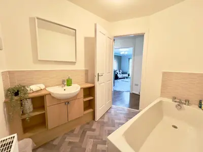 a bathroom with a white tub and a sink and a bath tub at Stylish City Apartment with Free Parking near Town in Glasgow