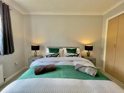a bedroom with a large white bed with two lamps at Stylish City Apartment with Free Parking near Town in Glasgow