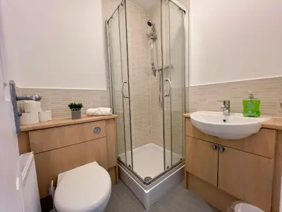 a bathroom with a shower and a toilet and a sink at Stylish City Apartment with Free Parking near Town in Glasgow