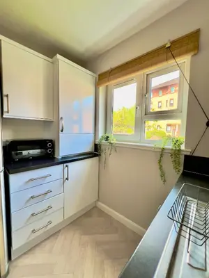 a kitchen with white cabinets and a window at Stylish City Apartment with Free Parking near Town in Glasgow
