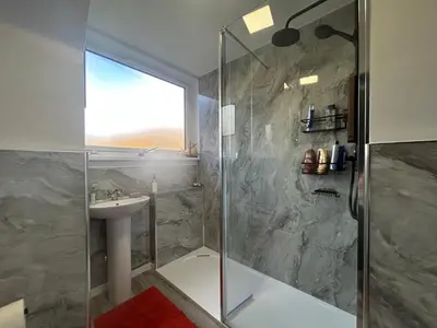 a bathroom with a glass shower and a sink at 29 Carnoch, Glencoe Village in Glencoe