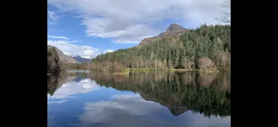 a view of a lake with trees and mountains at 29 Carnoch, Glencoe Village in Glencoe