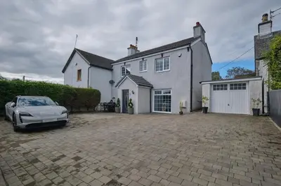 a white car parked in front of a white house at Stay Torrance-Village Home Near Glasgow in Glasgow