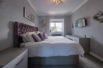 a bedroom with a bed and a window at Stay Torrance-Village Home Near Glasgow in Glasgow