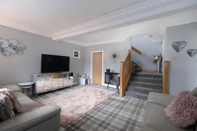 a living room with a couch and a television at Stay Torrance-Village Home Near Glasgow in Glasgow
