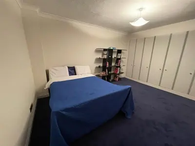 a room with a bed with a blue sheet on it at 14 Maple Mews in Moffat