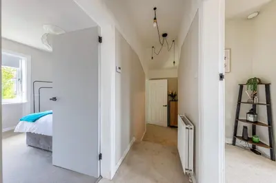 a bedroom with white walls and a bed in a room at Modern 3 Bedroom home in Kings Park in Polmadie