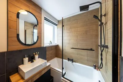 a bathroom with a sink and a shower and a mirror at Modern 3 Bedroom home in Kings Park in Polmadie