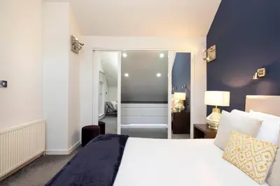 a bedroom with a white bed and a bathroom at Chic Edinburgh 3-Bedroom 2-Storey House near City Centre with Free Parking in Edinburgh