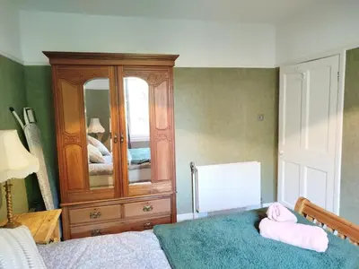 a bedroom with a dresser and two towels on a bed at Lovely place at Stenhouse in Edinburgh