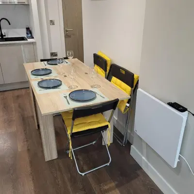 a table in a kitchen with yellow chairs around it at Riverside Apartment in Moffat