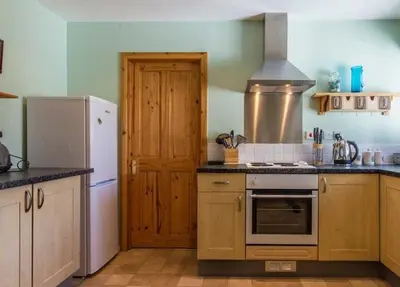 a kitchen with a refrigerator and a stove top oven at Spacious holiday home with stunning sea views in Whiting Bay