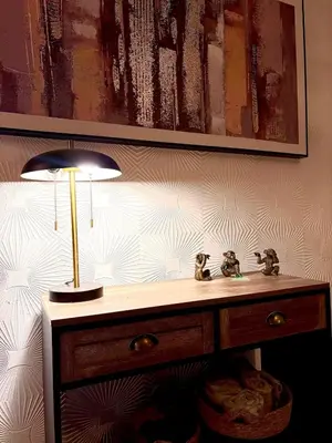 a table with a lamp on a wall with a painting at Cozy corner-Sleeps 8 guest Entire house Glasgow very central in Glasgow