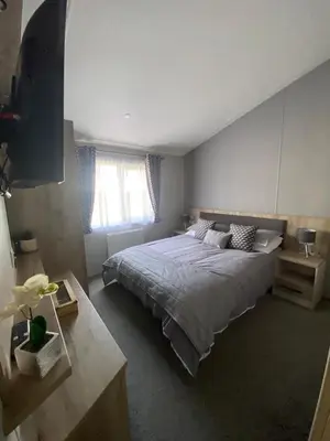 a bedroom with a large bed and a window at Wemyss Bay Mapleton Elite in Wemyss Bay