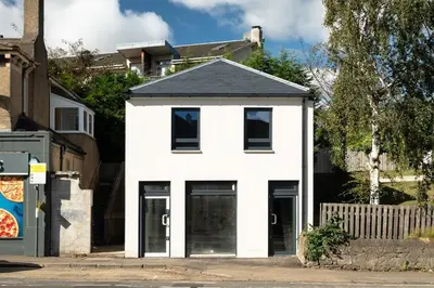 a white house with a black roof at Stunning upper villa stay in the City! in Edinburgh