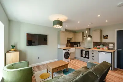 a living room with a couch and a kitchen at Stunning upper villa stay in the City! in Edinburgh