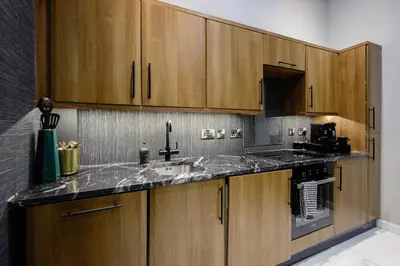 a kitchen with wooden cabinets and a sink at Stylish Edinburgh Apartment in Edinburgh