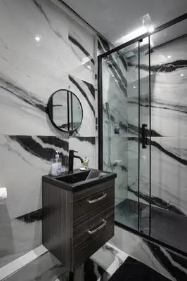 a bathroom with a sink and a glass shower at Stylish Edinburgh Apartment in Edinburgh