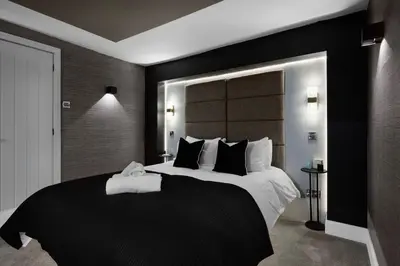 a bedroom with a large bed with a black headboard at Stylish Edinburgh Apartment in Edinburgh