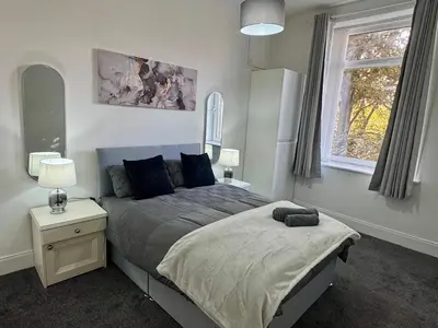 a bedroom with a large bed and a window at Comfort in the East in Glasgow