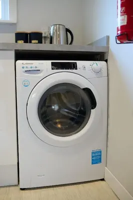a white washing machine sitting under a counter at Charming 2BR Oban Home - Quiet area with free parking in Oban