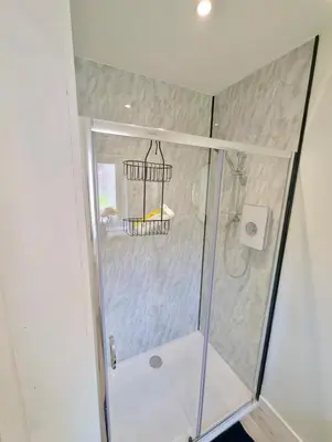 a shower with a glass door in a bathroom at YSquared studio in Falkirk