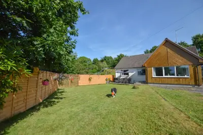 a dog sitting in a yard next to a fence at Stunning Coastal Home - Garden, Views, Pet Friendly in Connel