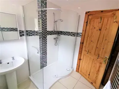 a bathroom with a shower and a toilet and a sink at Stunning Coastal Home - Garden, Views, Pet Friendly in Connel