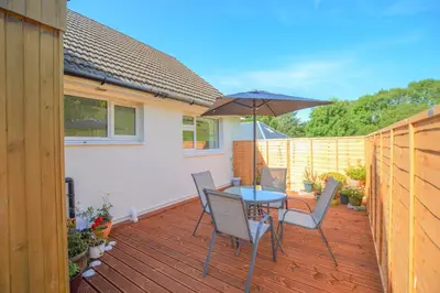 a patio with a table and chairs and an umbrella at Stunning Coastal Home - Garden, Views, Pet Friendly in Connel