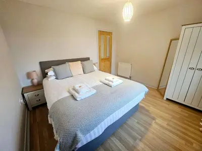 a bedroom with a bed with two towels on it at Stunning Coastal Home - Garden, Views, Pet Friendly in Connel