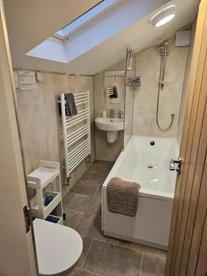 a bathroom with a tub and a toilet and a sink at Morton Mains Cottage