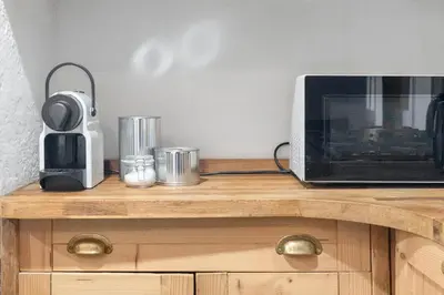 a microwave sitting on top of a wooden table at Charming Central Stay in Moffat