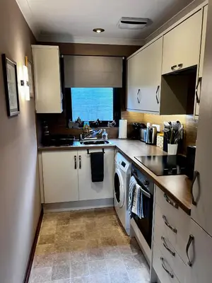 a kitchen with a washer and dryer in it at The Cottage at Craigavon House in Ballachulish