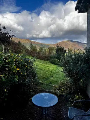 a table in a yard with a view of a field at The Cottage at Craigavon House in Ballachulish
