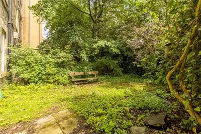 a park with a bench in the middle of a garden at 3 Bedrooms Flat in Central Edinburgh New Town , Lothian Road in Edinburgh