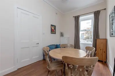 a dining room with a wooden table and chairs at 3 Bedrooms Flat in Central Edinburgh New Town , Lothian Road in Edinburgh