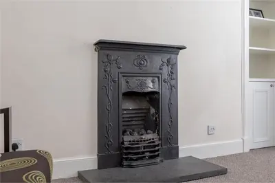 a black fireplace in a room with a white wall at 3 Bedrooms Flat in Central Edinburgh New Town , Lothian Road in Edinburgh