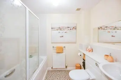 a white bathroom with a shower and a sink at Amazing Apartment by The Wallace Monument in Stirling