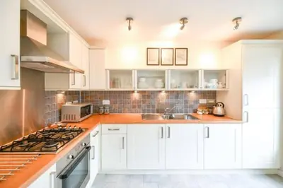 a kitchen with white cabinets and a stove top oven at Amazing Apartment by The Wallace Monument in Stirling