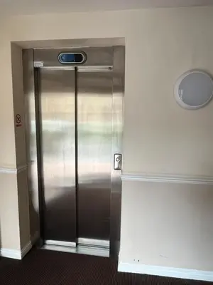 a stainless steel refrigerator in the corner of a room at Amazing Apartment by The Wallace Monument in Stirling