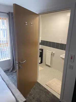 a room with a bathroom with a door and a sink at Maison 109 Suite - Modern City Apartment in Glasgow