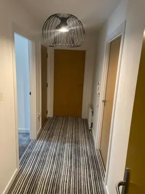 an empty hallway with a large chandelier at Maison 109 Suite - Modern City Apartment in Glasgow