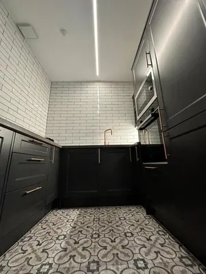 a kitchen with black cabinets and a tile floor at Glasgow West End Tenement Apartment in Glasgow