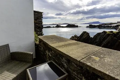 a balcony with a view of a body of water at Old Brewery Cottage - Ellenabeich, Easdale - Isle of Seil