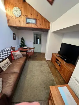 a living room with a couch and a tv at Old Brewery Cottage - Ellenabeich, Easdale - Isle of Seil