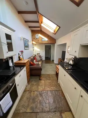a kitchen with a couch and a living room at Old Brewery Cottage - Ellenabeich, Easdale - Isle of Seil