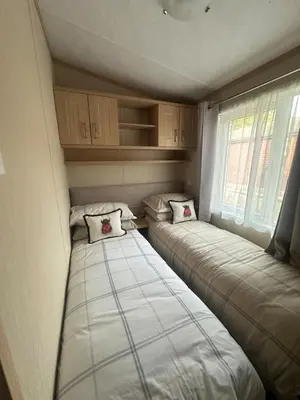 two beds in a small room with a window at Glen-coo in Auchterarder