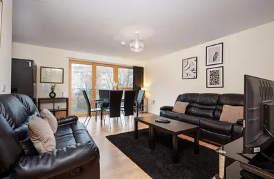 a living room with a leather couch and a table at 2BR Apartment with Parking Near Southside and Queens Park in Mansewood